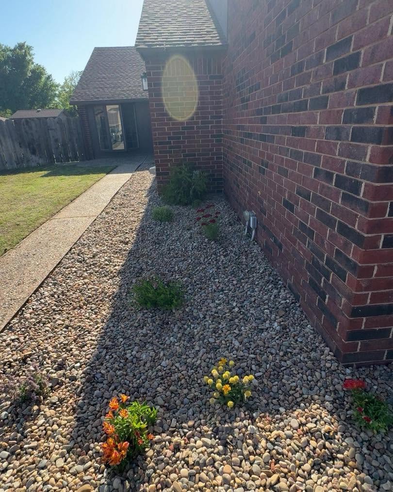 A newly installed rock bed with colorful seasonal flowers